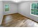 Bright bedroom featuring two windows and wood-look flooring at 355 New Marietta Hwy, Roswell, GA 30075