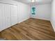 Clean bedroom showcasing wood floors, a window, and a spacious closet at 355 New Marietta Hwy, Roswell, GA 30075