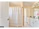Well-lit bathroom with dual sinks, white cabinetry, and a shower with a curtain at 4213 Bretdale Nw Run, Kennesaw, GA 30152