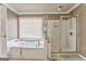 Bright bathroom features a soaking tub, a glass-enclosed shower, and a window for natural light at 4213 Bretdale Nw Run, Kennesaw, GA 30152
