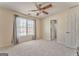 Bright, carpeted bedroom featuring a ceiling fan and a large window with curtains at 4213 Bretdale Nw Run, Kennesaw, GA 30152