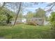 Expansive backyard with lush green grass, mature trees, and a wooden deck attached to the house at 474 Autumn Dr, Riverdale, GA 30274