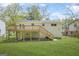 Large backyard featuring a wooden deck and stairs, overlooking a green lawn with a wooden fence at 474 Autumn Dr, Riverdale, GA 30274