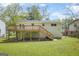 View of the back of the house and backyard with deck, stairs, and a grassy lawn at 474 Autumn Dr, Riverdale, GA 30274