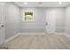A bedroom with neutral tones, wood floors, a bright window, and a white painted door at 474 Autumn Dr, Riverdale, GA 30274