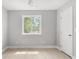 This bedroom features a light gray wall, a light wood floor, and a window with natural light at 474 Autumn Dr, Riverdale, GA 30274
