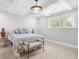 Light-filled bedroom featuring coffered ceilings and a decorative bench at the foot of the bed at 474 Autumn Dr, Riverdale, GA 30274