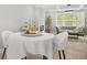 Open dining area with white chairs, decorative table setting and view to living area at 474 Autumn Dr, Riverdale, GA 30274