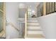 Light-filled entryway with wood and white stairs, with a partial view of the kitchen at 474 Autumn Dr, Riverdale, GA 30274
