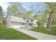 Charming gray two-story home featuring an attached garage and well-maintained front lawn, and concrete stairs at 474 Autumn Dr, Riverdale, GA 30274