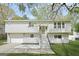Charming gray two-story home featuring an attached garage, and steps to the front door at 474 Autumn Dr, Riverdale, GA 30274