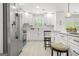 Bright and airy kitchen with white cabinets, stainless steel appliances, and light wood flooring at 474 Autumn Dr, Riverdale, GA 30274
