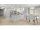 Well-lit kitchen with white cabinets, stainless steel appliances, central island, and adjacent dining area at 474 Autumn Dr, Riverdale, GA 30274