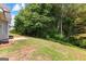 Backyard features a small concrete patio, grass and privacy trees at 4506 White Rd, Douglasville, GA 30135