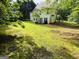 Large green backyard with a two-story white house and mature trees at 110 Shelby Oaks Trl, Covington, GA 30016