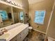 Bright bathroom with a large mirror, vanity with white cabinets, and tile flooring at 110 Shelby Oaks Trl, Covington, GA 30016