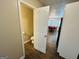 Hallway view showing the bathroom and dining room with chandelier and tiled floors at 110 Shelby Oaks Trl, Covington, GA 30016