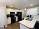 Well-lit kitchen with stainless steel sink, black appliances, and white cabinets at 110 Shelby Oaks Trl, Covington, GA 30016