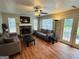 Cozy living room with stone fireplace, ceiling fan, and access to the backyard at 110 Shelby Oaks Trl, Covington, GA 30016