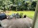 Back patio with outdoor table, chairs, grill, and view of the backyard at 110 Shelby Oaks Trl, Covington, GA 30016