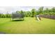 Large backyard featuring a trampoline, swing set, and playhouse; all with a lush green lawn at 4752 Albany Way, South Fulton, GA 30331