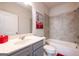 A well-lit bathroom with a combined tub and shower and tile walls at 4752 Albany Way, South Fulton, GA 30331