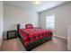 Bedroom featuring neutral walls, carpet floors, and a black leather bed dressed with a red and black plaid blanket at 4752 Albany Way, South Fulton, GA 30331