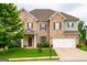 Traditional two-story brick home featuring an attached two-car garage and manicured front lawn at 4752 Albany Way, South Fulton, GA 30331