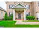 Inviting covered front porch with white columns, manicured lawn, and lush landscaping at 4752 Albany Way, South Fulton, GA 30331