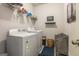 Bright laundry room with modern washer and dryer, wire shelving, and decorative wall art at 4752 Albany Way, South Fulton, GA 30331