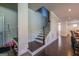 Staircase featuring dark wood steps, white paneled walls, and black iron railings, with view to dining area at 4752 Albany Way, South Fulton, GA 30331