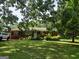 Charming red brick home with a lush front yard and mature shade trees offers great curb appeal at 856 New Hope Rd, Fayetteville, GA 30214