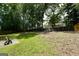 Large backyard with mature trees, a partially fenced yard and green grass at 9067 Bob Jackson Dr, Jonesboro, GA 30238