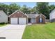 Charming brick home with two-car garage, manicured lawn and mature trees at 9067 Bob Jackson Dr, Jonesboro, GA 30238