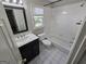Bathroom with a dark vanity, window, bathtub and shower combination featuring white tiled walls at 3773 Summer Rose Dr, Atlanta, GA 30341