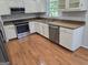 Well-lit kitchen features stainless steel appliances, granite countertops, and wood flooring at 3773 Summer Rose Dr, Atlanta, GA 30341