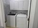 Well-lit laundry room with white washer and dryer and ample cabinet space for storage at 3773 Summer Rose Dr, Atlanta, GA 30341
