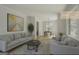 Bright living room with a gray sofa set, area rug, artwork, and a dining area near a large window at 1684 Lake Harbin Rd, Morrow, GA 30260