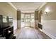 Bright living room featuring a bay window, wood-look floors, and wainscoting details at 465 Harris Dr, Conyers, GA 30012