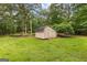 Charming barn in a lush green, wooded backyard with wooden fence at 135 Birdsong Ln, Fayetteville, GA 30215