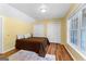 Bedroom with vinyl wood floors, a bed, large windows, neutral paint, and white closet doors at 135 Birdsong Ln, Fayetteville, GA 30215