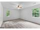 Neutral bedroom with a ceiling fan and bright, natural light from the windows at 135 Birdsong Ln, Fayetteville, GA 30215