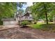 View of a home featuring a long driveway, a two car garage, and a lush green lawn at 135 Birdsong Ln, Fayetteville, GA 30215