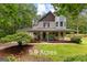 Charming two-story home with a large porch and beautiful landscaping on 5.9 acres at 135 Birdsong Ln, Fayetteville, GA 30215