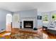Bright and airy living room with fireplace, hardwood floors, and large windows with views of backyard at 135 Birdsong Ln, Fayetteville, GA 30215