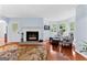 Comfortable living room with a fireplace, bay windows, hardwood floors, and cozy seating at 135 Birdsong Ln, Fayetteville, GA 30215