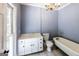 Bathroom featuring a white vanity, chandelier, toilet, and vintage tub with gold fixtures at 5780 Pumkintown Rd, Douglasville, GA 30135