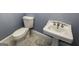 Classic white toilet and pedestal sink with stylish marble-look tile flooring at 5780 Pumkintown Rd, Douglasville, GA 30135