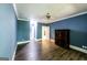 Spacious bedroom featuring hardwood floors, blue painted walls and ceiling fan at 5780 Pumkintown Rd, Douglasville, GA 30135