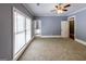 Bright bedroom featuring light blue walls, carpet, and multiple window views with white trim at 5780 Pumkintown Rd, Douglasville, GA 30135